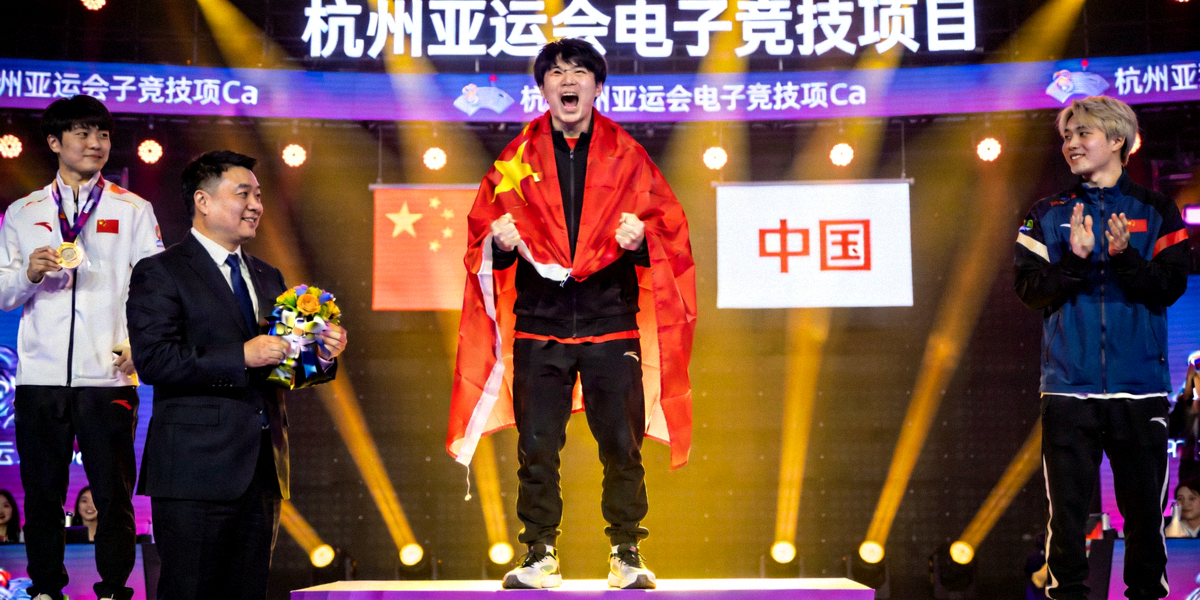 亚运会电竞赛事颁奖典礼，中国代表队选手身披国旗站在领奖台上